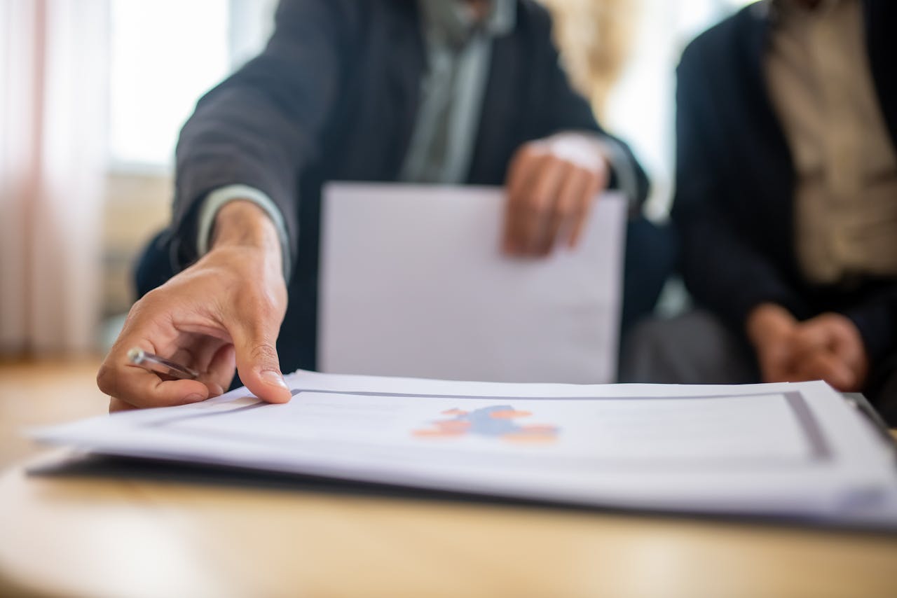 Startseite Close-up of a businessman reviewing important documents at a desk in an office setting.